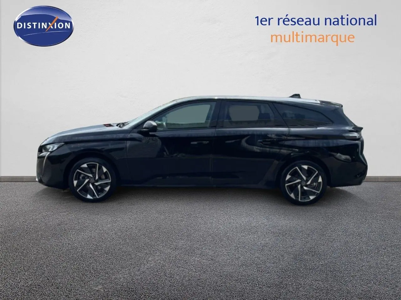 Profil latéral droit d'une Peugeot 308 SW hybride noire métallisée, avec jantes alliage et vitres teintées.