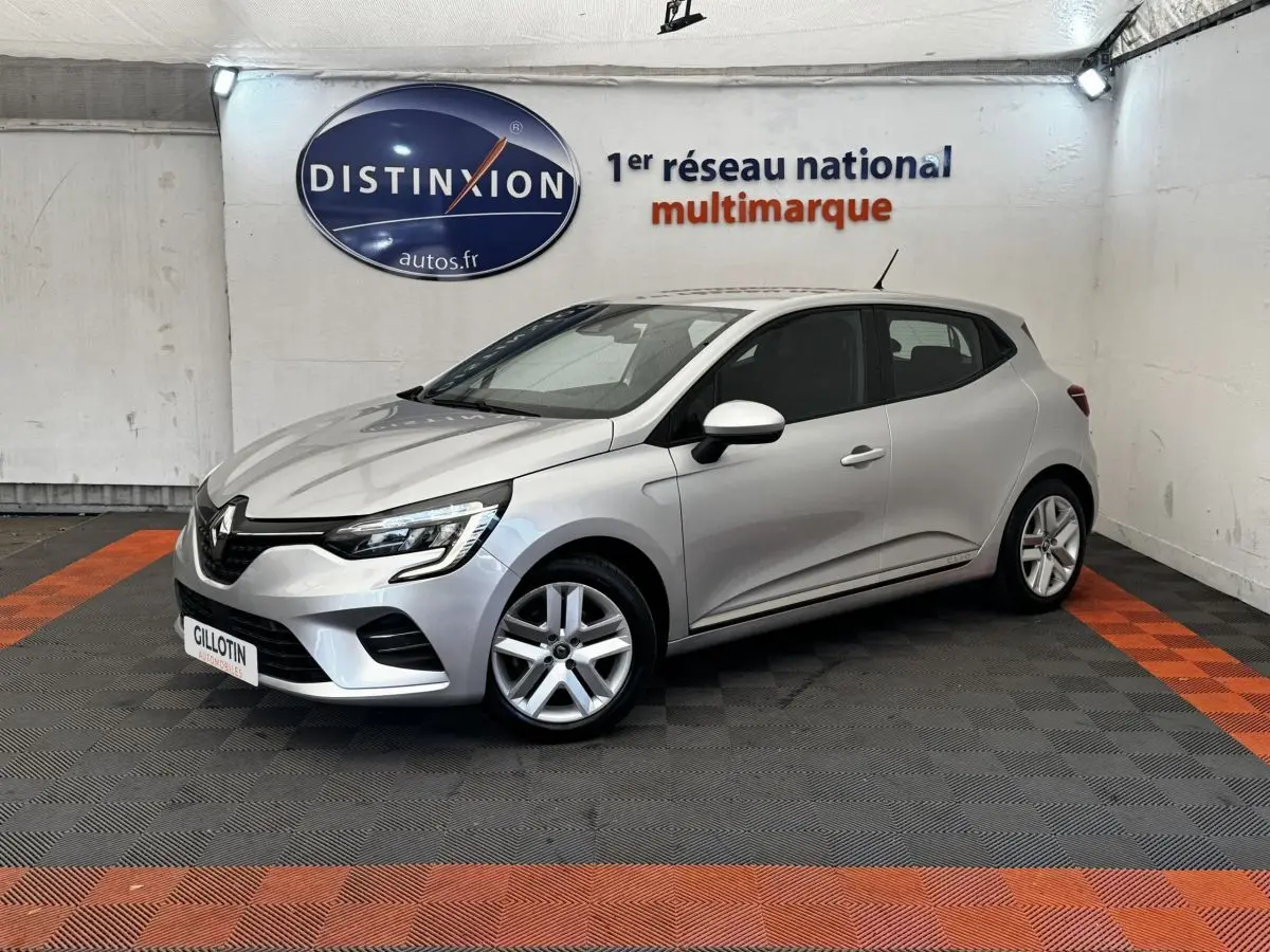 Renault Clio Business E-TECH 140 gris clair vue 3/4 avant droit dans un showroom avec sol noir et orange.