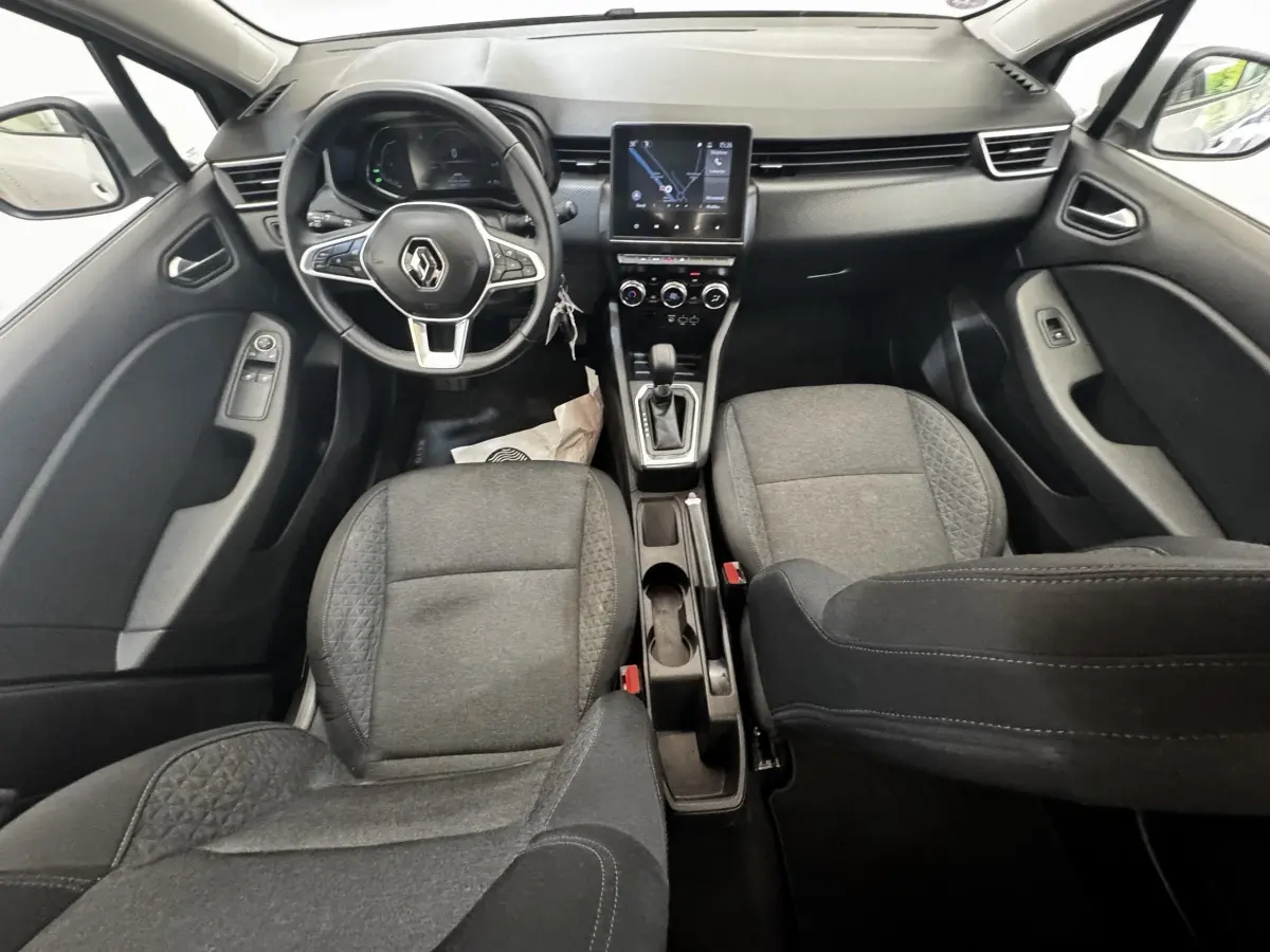 Vue intérieure avant de la Renault Clio Business E-TECH 140 gris clair, avec volant multifonctions et écran tactile central.