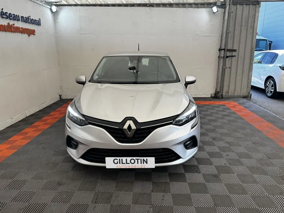 Renault Clio Business E-TECH 140 gris clair vue de face dans un showroom avec logo Renault bien visible.