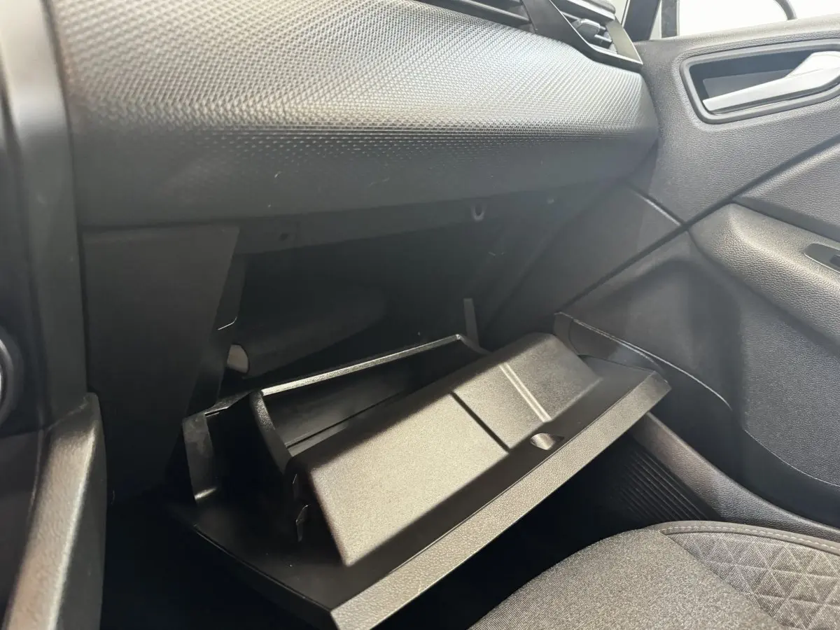Vue intérieure côté passager de la boîte à gants ouverte dans une Renault Clio Business E-TECH 140 gris clair.