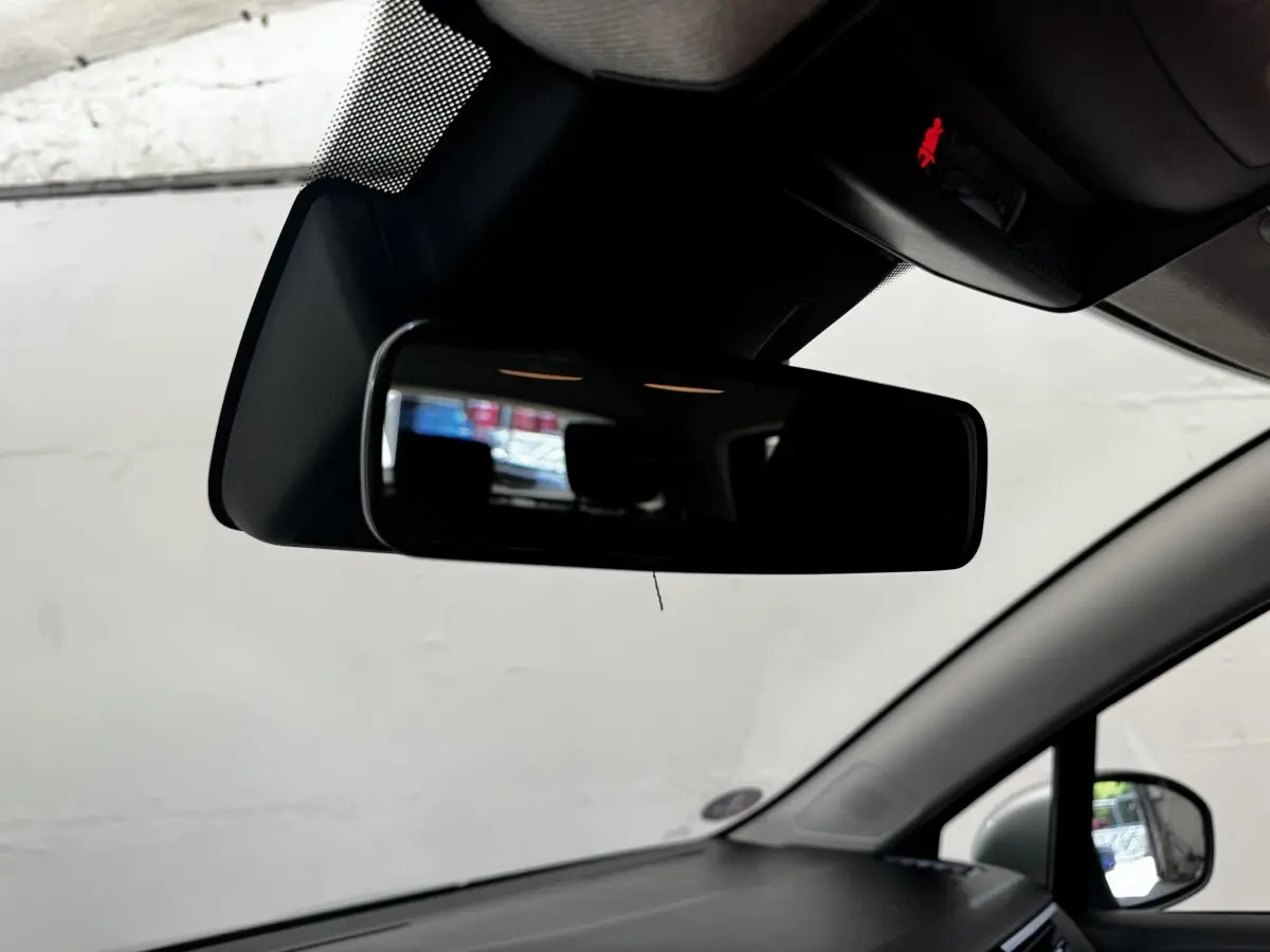 Rétroviseur intérieur de Renault Clio Business E-TECH 140 gris clair, vue centrée sur le miroir et pare-brise.