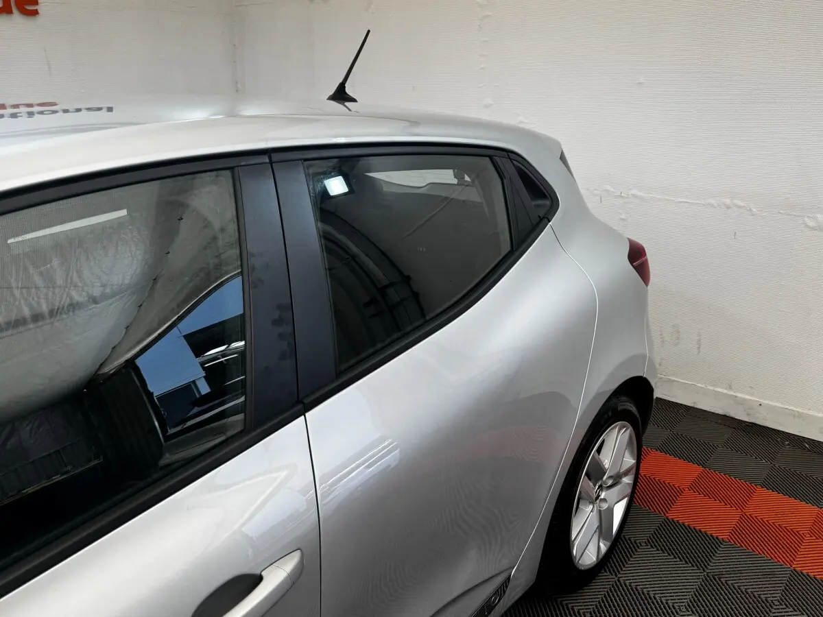 Vue côté arrière droit d'une Renault Clio Business E-TECH 140 gris clair, mettant en valeur la porte arrière et la jante alliage.
