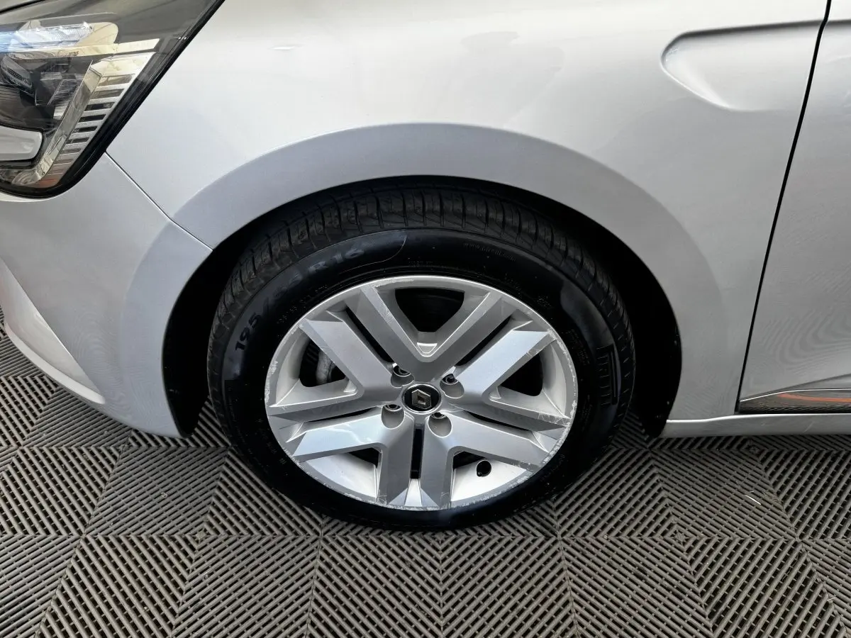 Gros plan sur la roue avant gauche gris clair de la Renault Clio Business E-TECH 140 avec jante alliage à cinq branches.