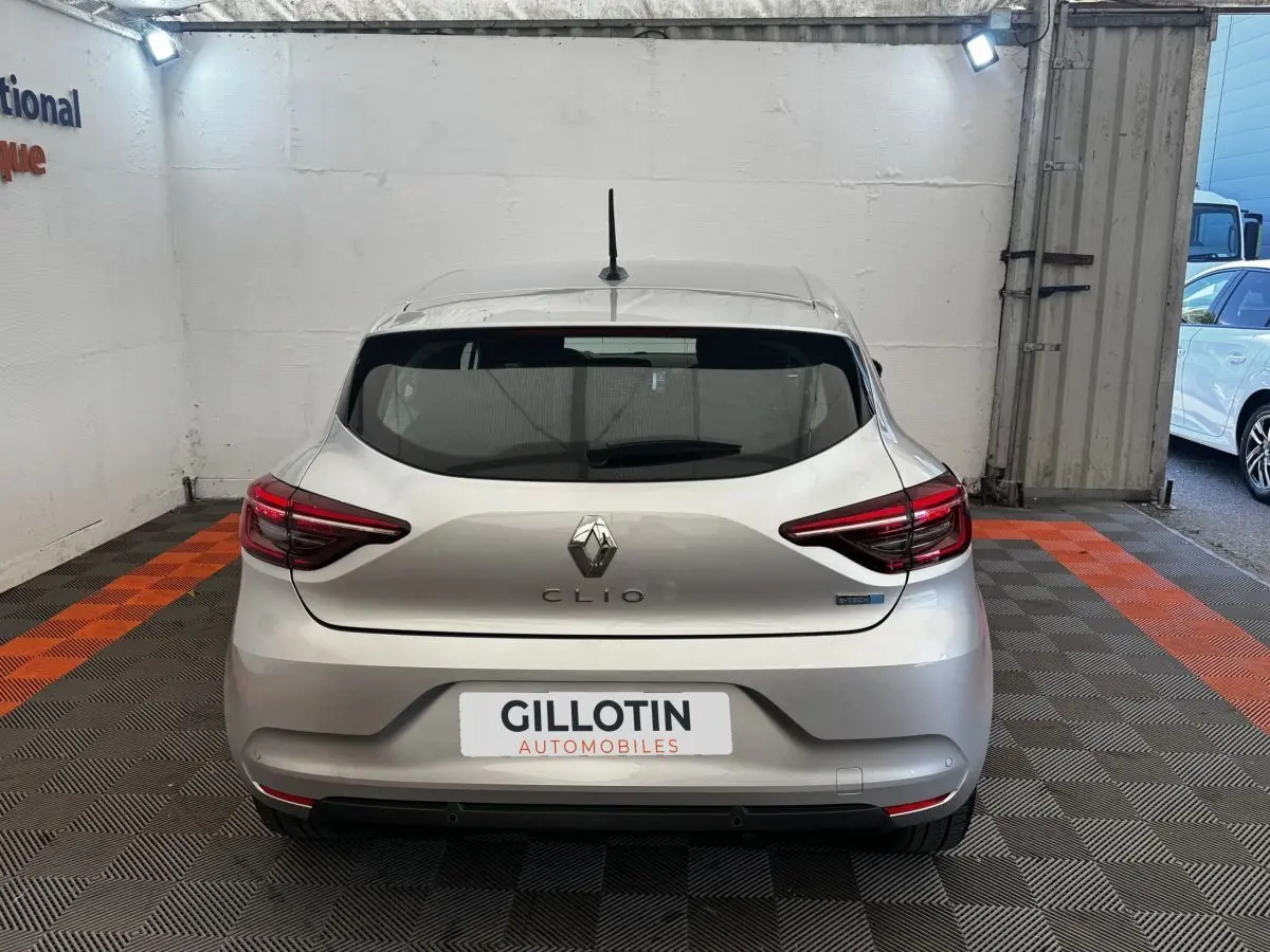 Vue arrière d'une Renault Clio Business E-TECH 140 gris clair, avec feux LED et logo central visible.