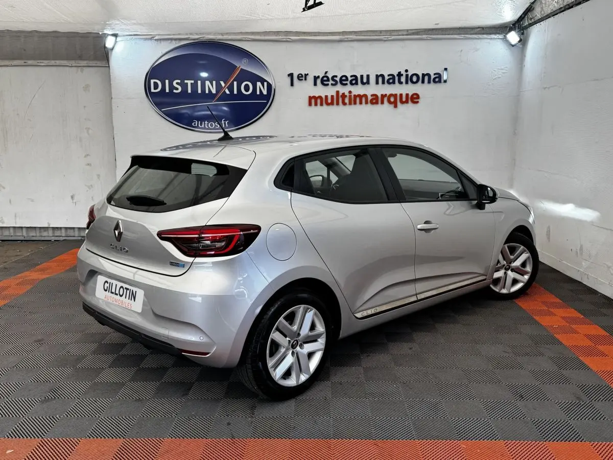 Vue 3/4 arrière droite d'une Renault Clio Business E-TECH 140 gris clair avec jantes alliage et feux LED.