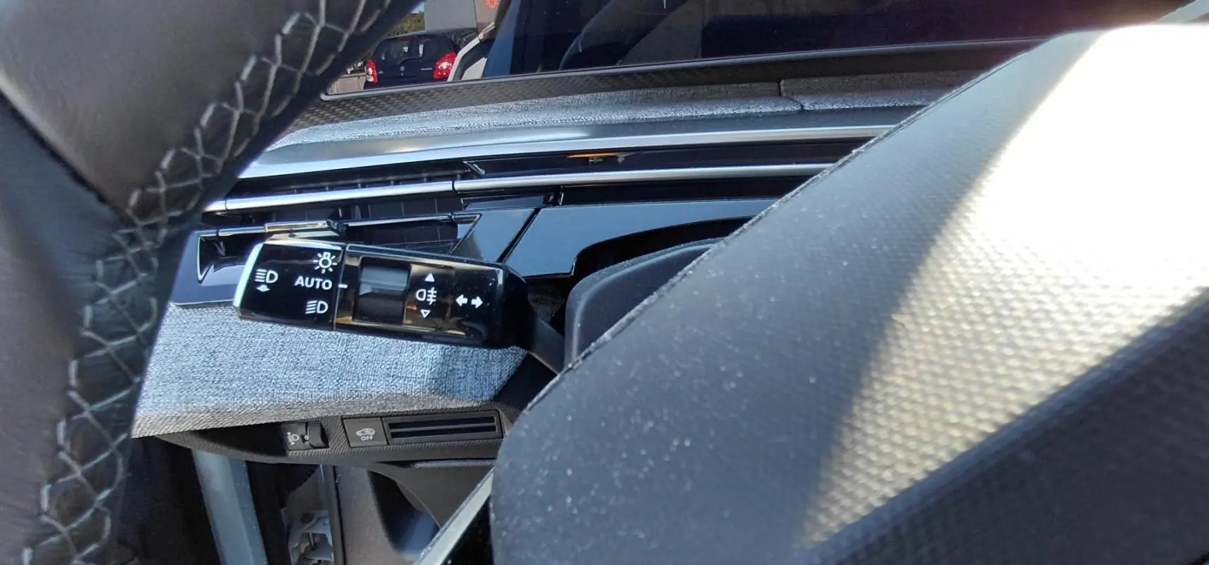 Gros plan sur la commande des feux et clignotants côté gauche du tableau de bord du Peugeot 5008 Hybrid 2025.