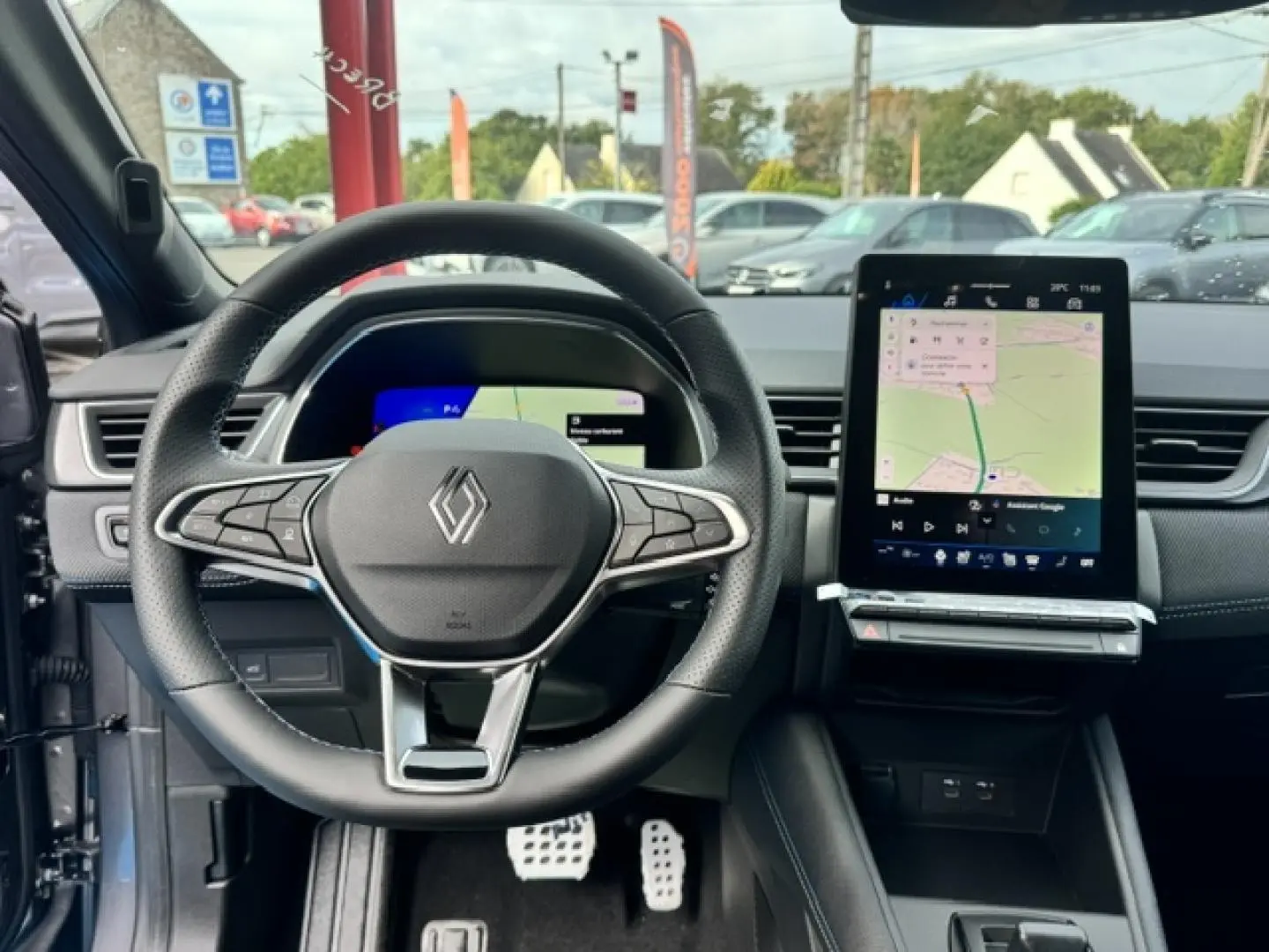Vue intérieure frontale du volant multifonction Renault Symbioz gris Cassiopée avec écran tactile central et tableau de bord numérique.