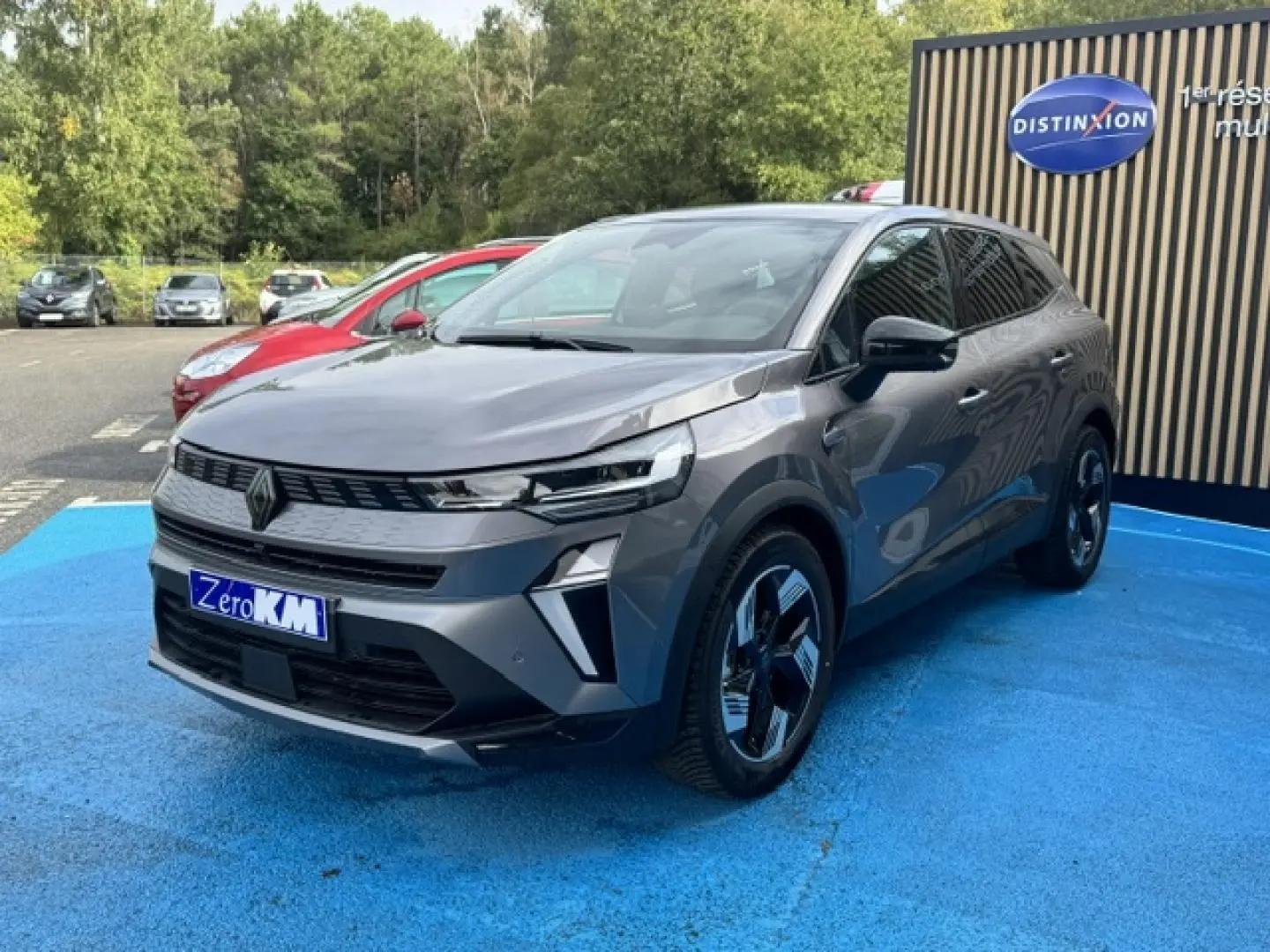 Renault Symbioz gris Cassiopée métallisé, vue 3/4 avant droit, avec jantes noires et détails modernes LED.
