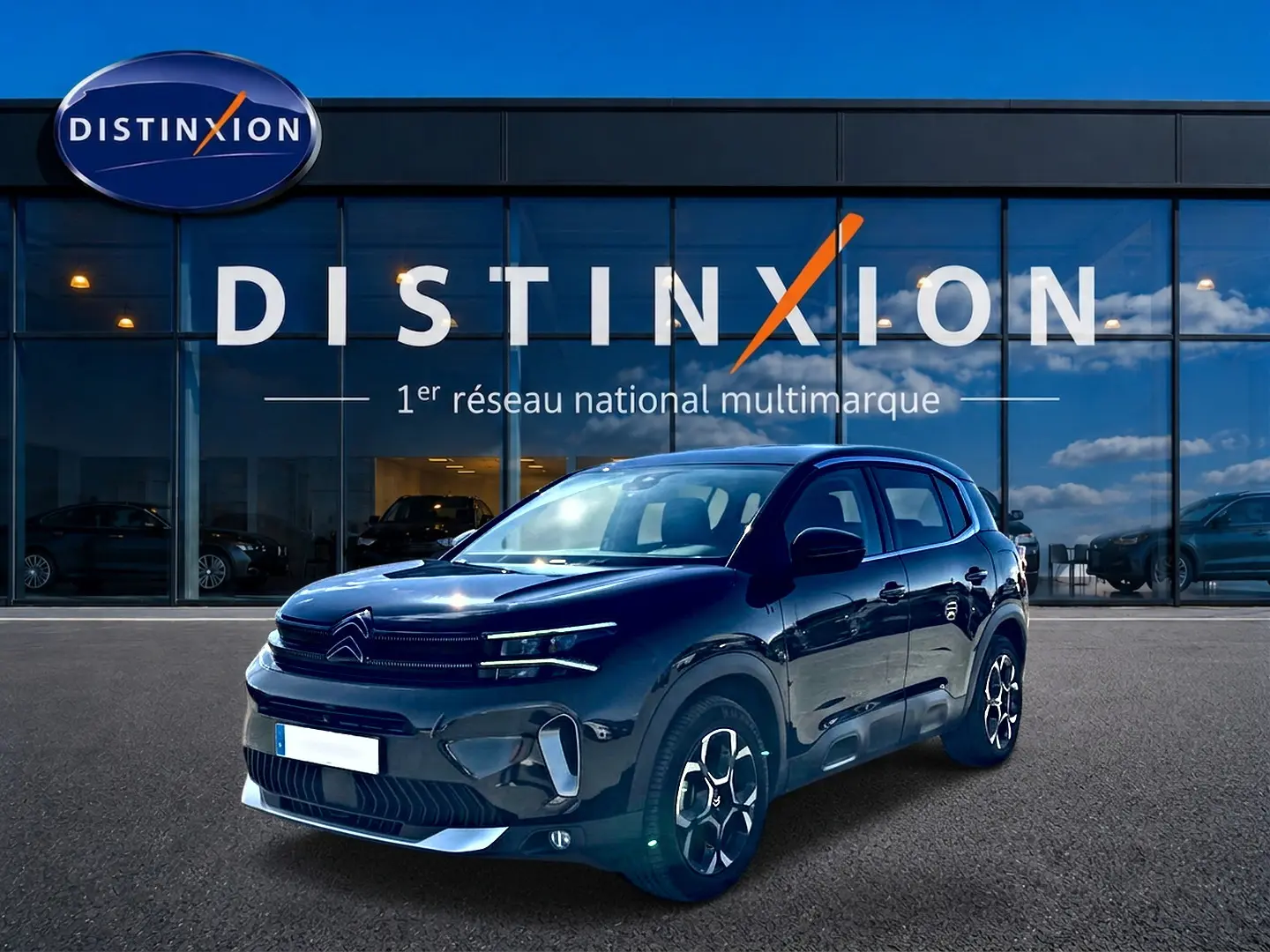Citroën C5 Aircross noir en 3/4 avant droit, avec jantes alu et calandre distinctive, devant un bâtiment vitré.