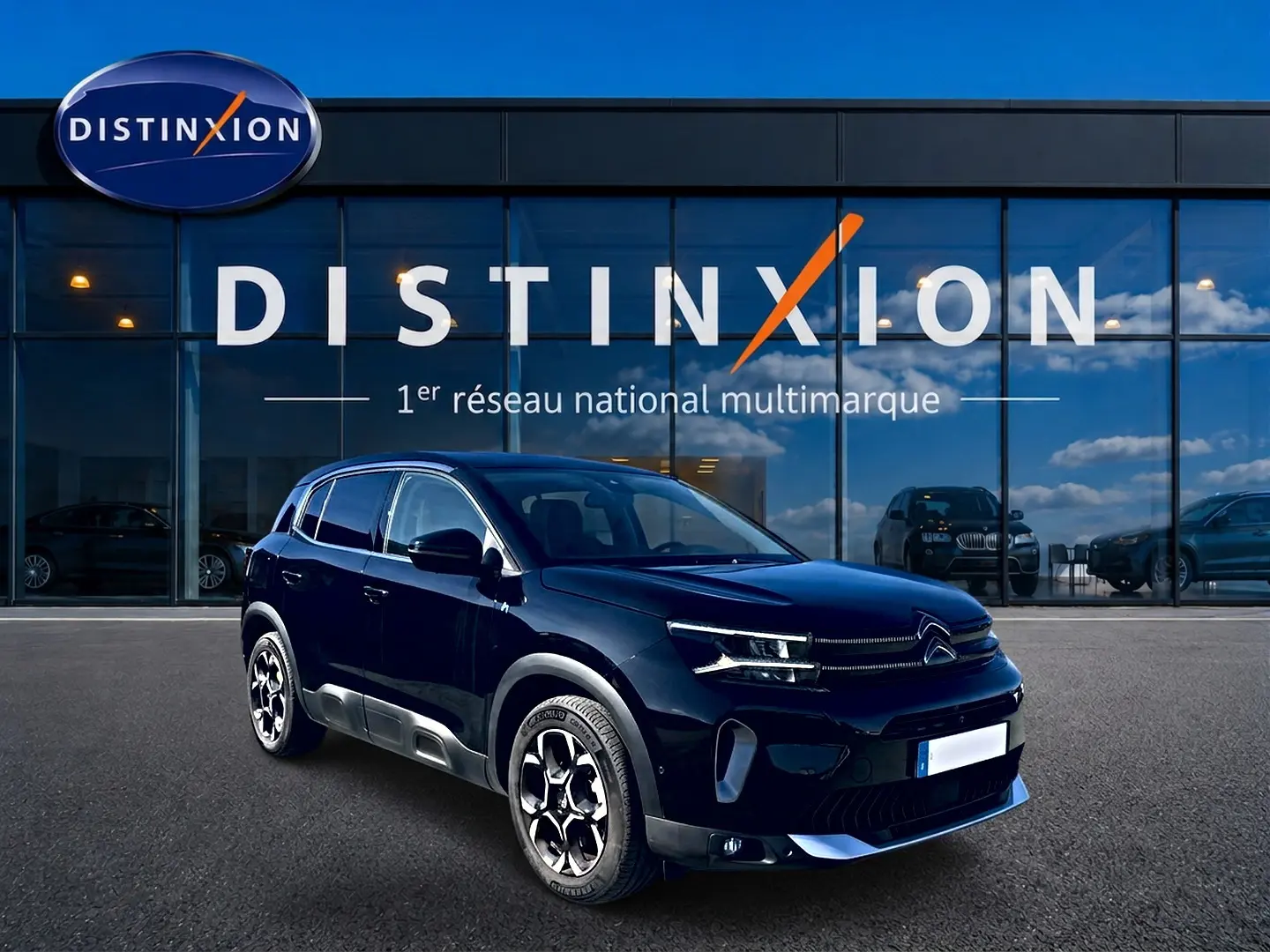Citroën C5 Aircross noir vue 3/4 avant droit, avec jantes alu et calandre distinctive devant showroom Distinxion.