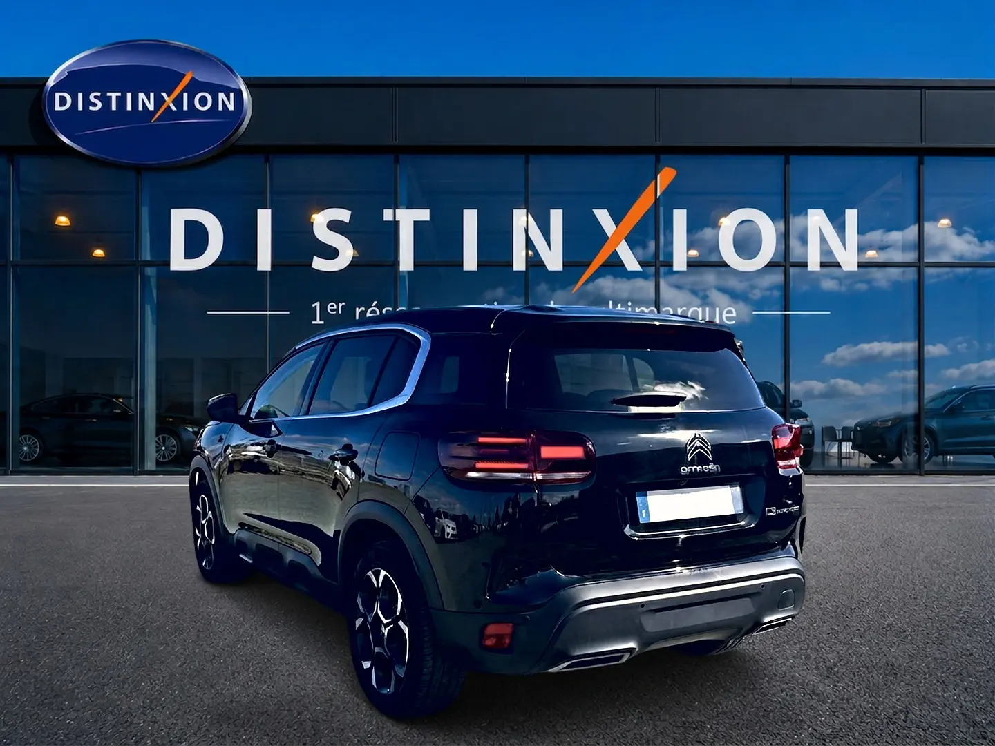 Vue 3/4 arrière droite d'un Citroën C5 Aircross noir 2024 avec feux arrière LED et jantes alliage.
