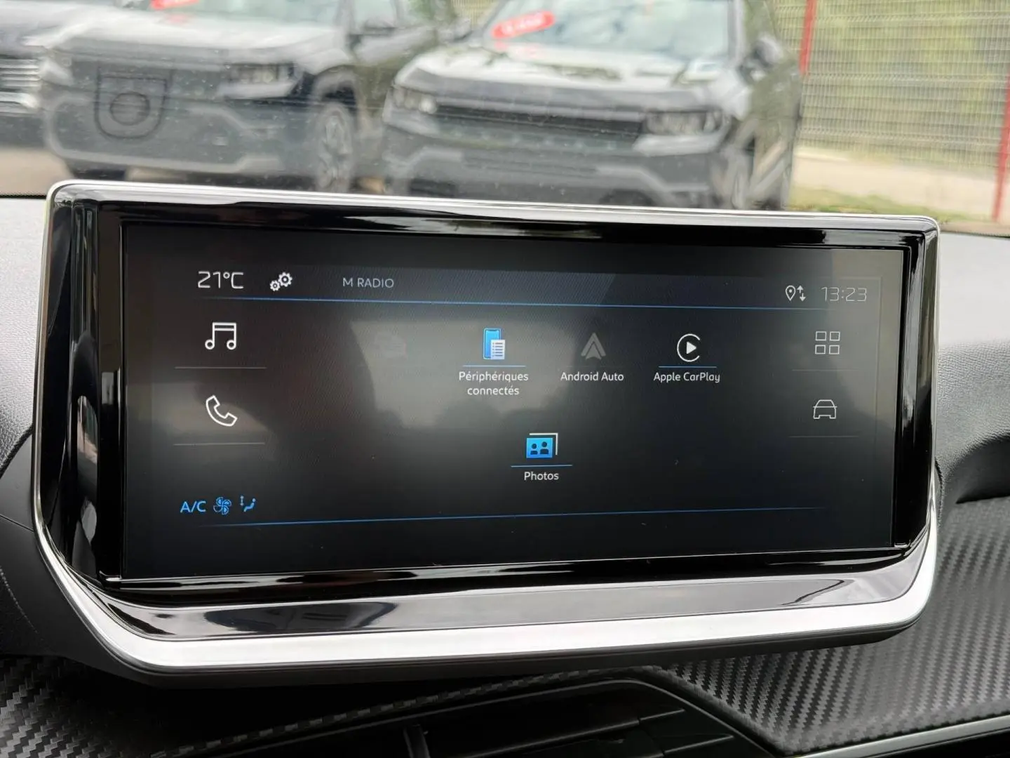Écran tactile central du tableau de bord de la Peugeot 208 noire, affichant les options Android Auto et Apple CarPlay.