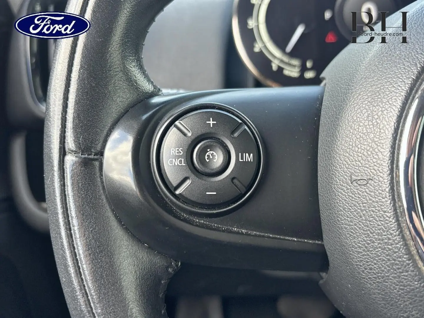 Gros plan sur le volant cuir noir du MINI Countryman Cooper D 2020, avec commandes de régulateur de vitesse visibles.