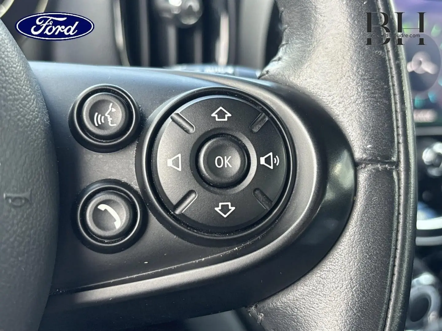 Boutons de commande audio et téléphone sur le volant cuir noir d'un MINI Countryman Cooper D 2020, vue rapprochée.