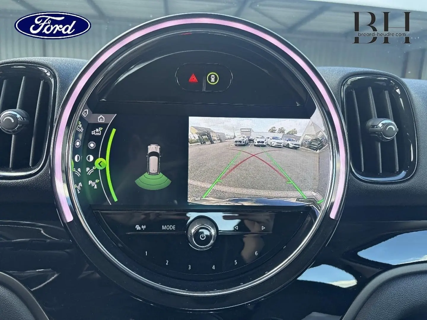Écran tactile rond affichant la caméra de recul et capteurs de stationnement d'une MINI Countryman noir Midnight.