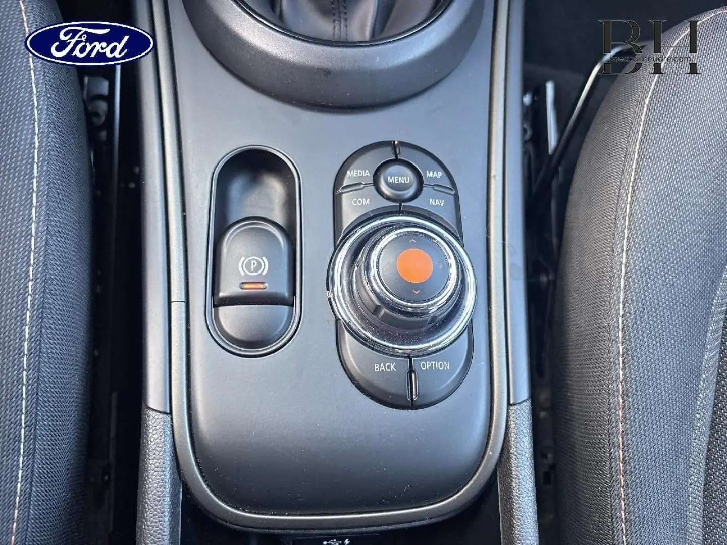 Vue plongeante sur la console centrale noire du MINI Countryman Cooper D 2020 avec commandes multimédia et frein à main électrique.