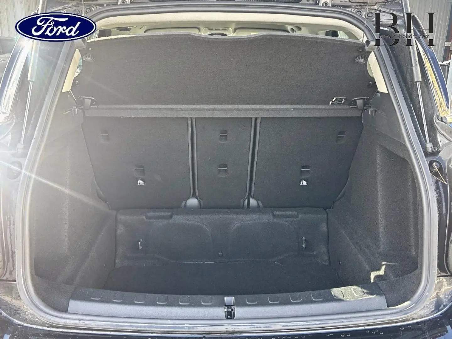 Coffre ouvert d’un MINI Countryman Midnight Black vu de l’arrière, montrant l’espace de chargement et la banquette arrière.