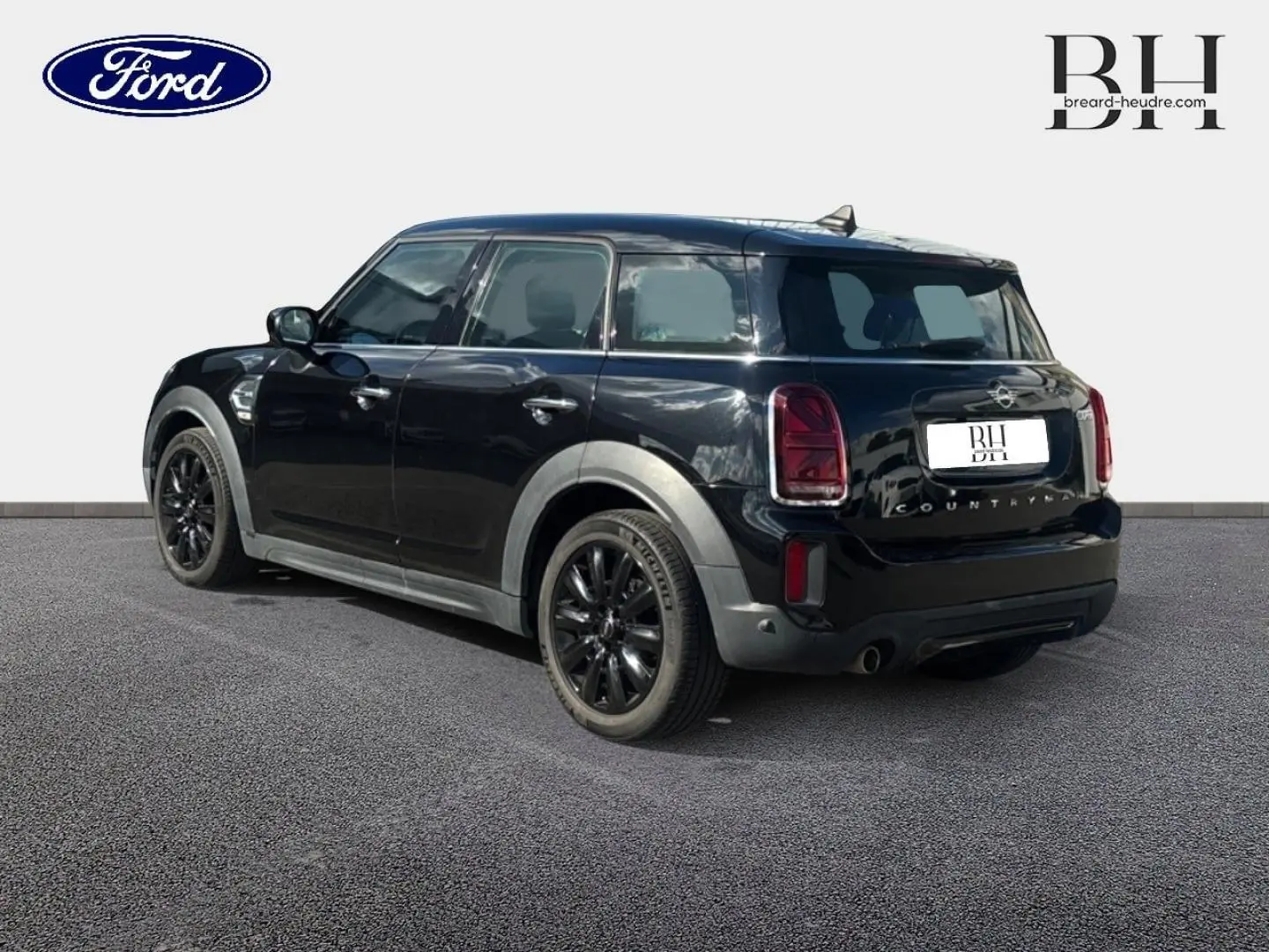 MINI Countryman Cooper D noir Midnight Black, vue 3/4 arrière droit avec jantes alu noires et bandes grises sur capot.