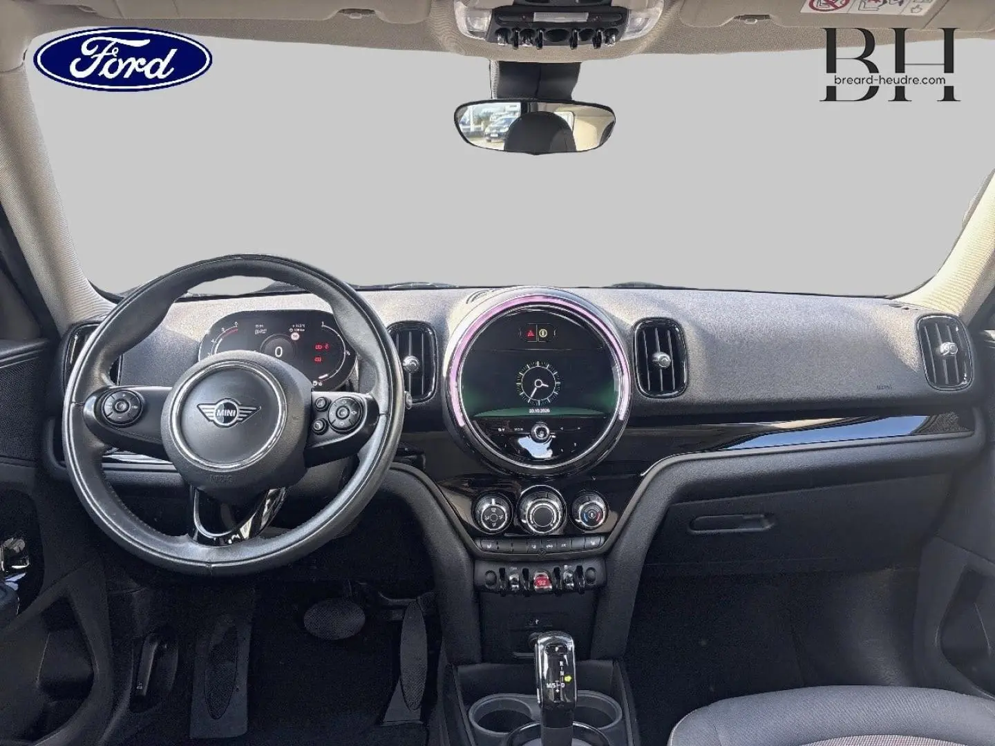 Vue intérieure frontale du tableau de bord noir du MINI Countryman Cooper D 2020 avec volant multifonction et écran circulaire central.