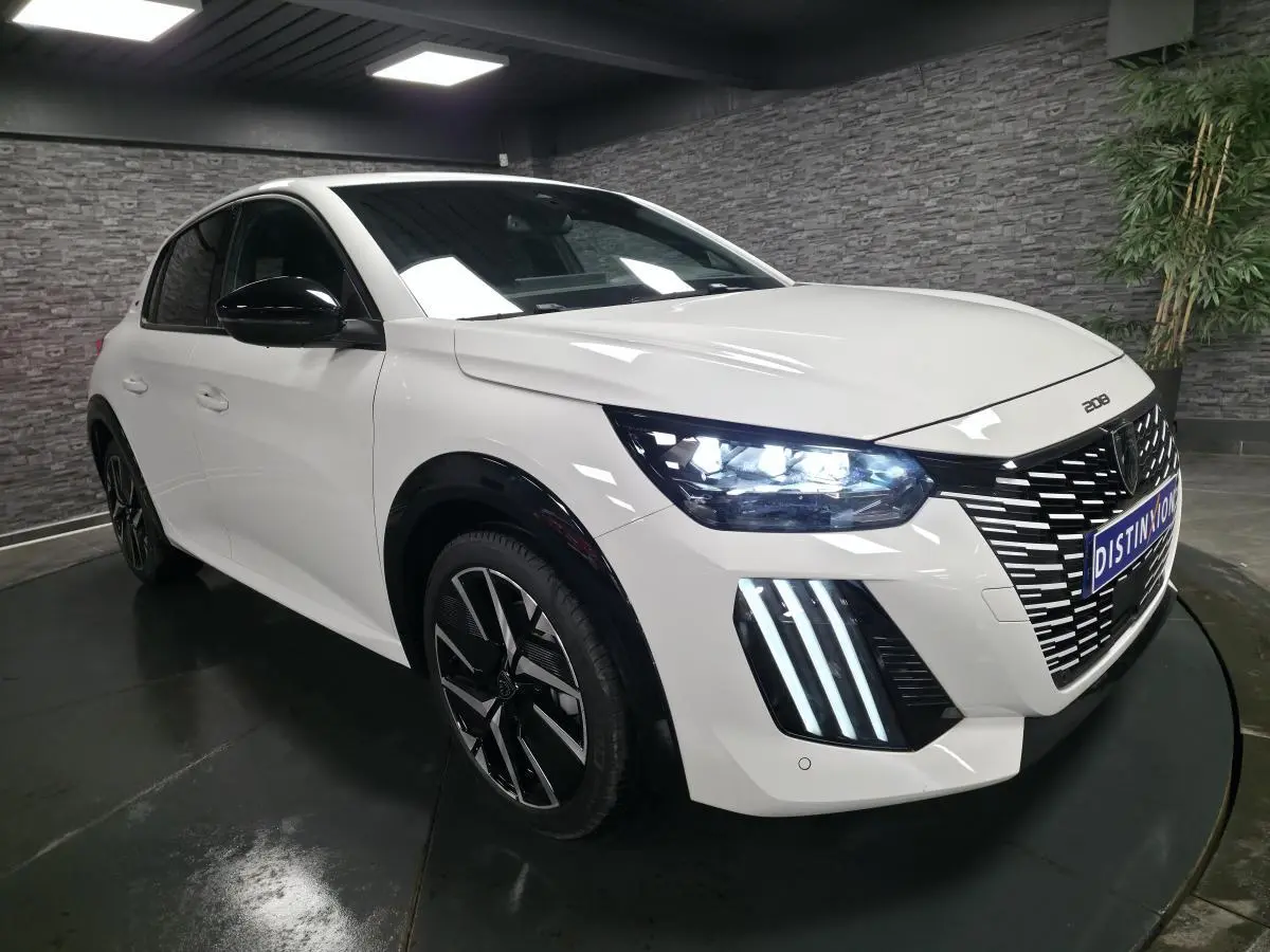 Peugeot 208 blanc banquise en 3/4 avant droit avec calandre noire et feux LED distinctifs allumés.