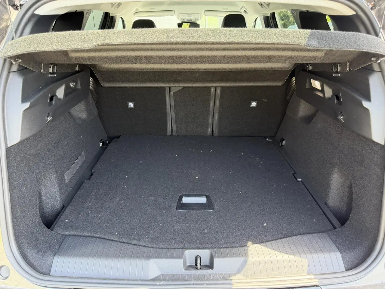 Coffre ouvert vu de l'arrière du Citroën C5 Aircross gris Platinium, montrant un espace de chargement spacieux et propre.
