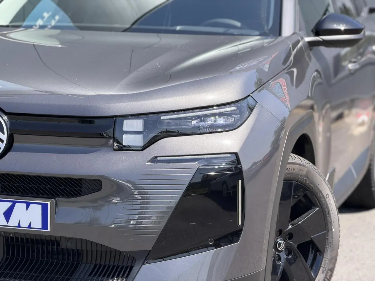 Vue avant droite rapprochée du Citroën C5 Aircross gris Platinium, mettant en valeur son optique LED et jante noire.