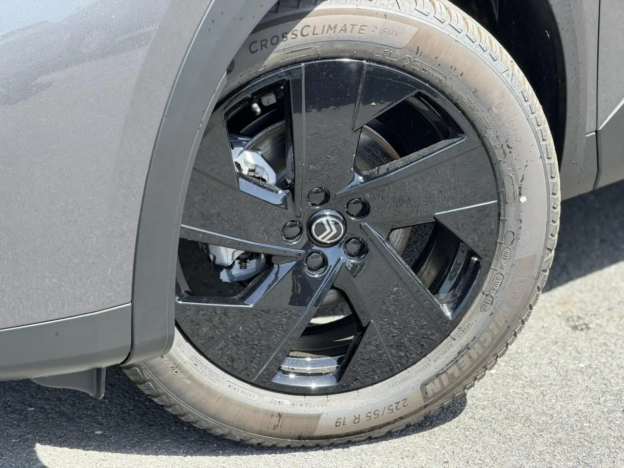 Gros plan sur la roue avant gauche du Citroën C5 Aircross gris Platinium avec jante alliage noire brillante.