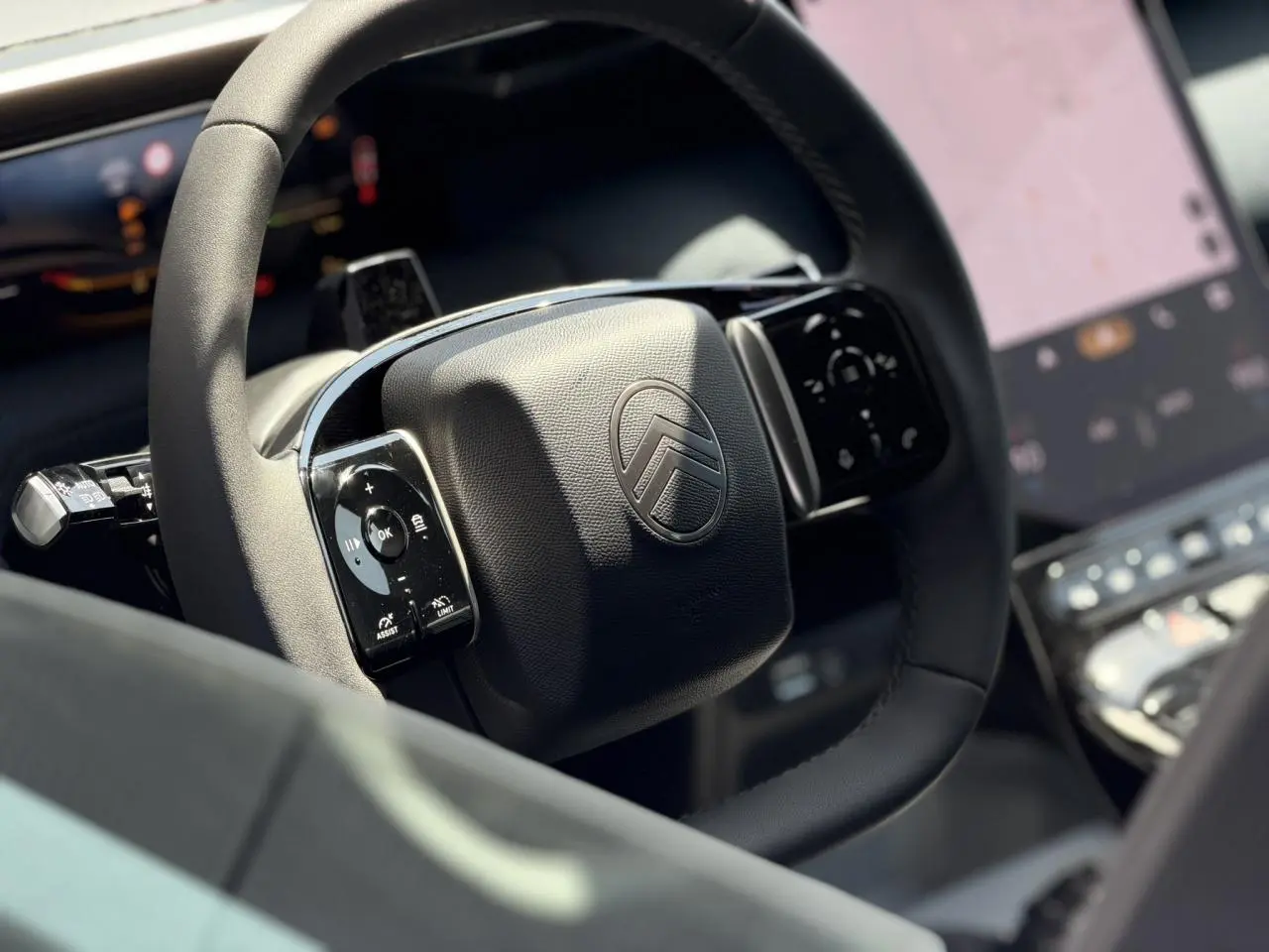 Gros plan sur le volant noir multifonctions Citroën du C5 Aircross 2026 avec écran tactile en arrière-plan flou.