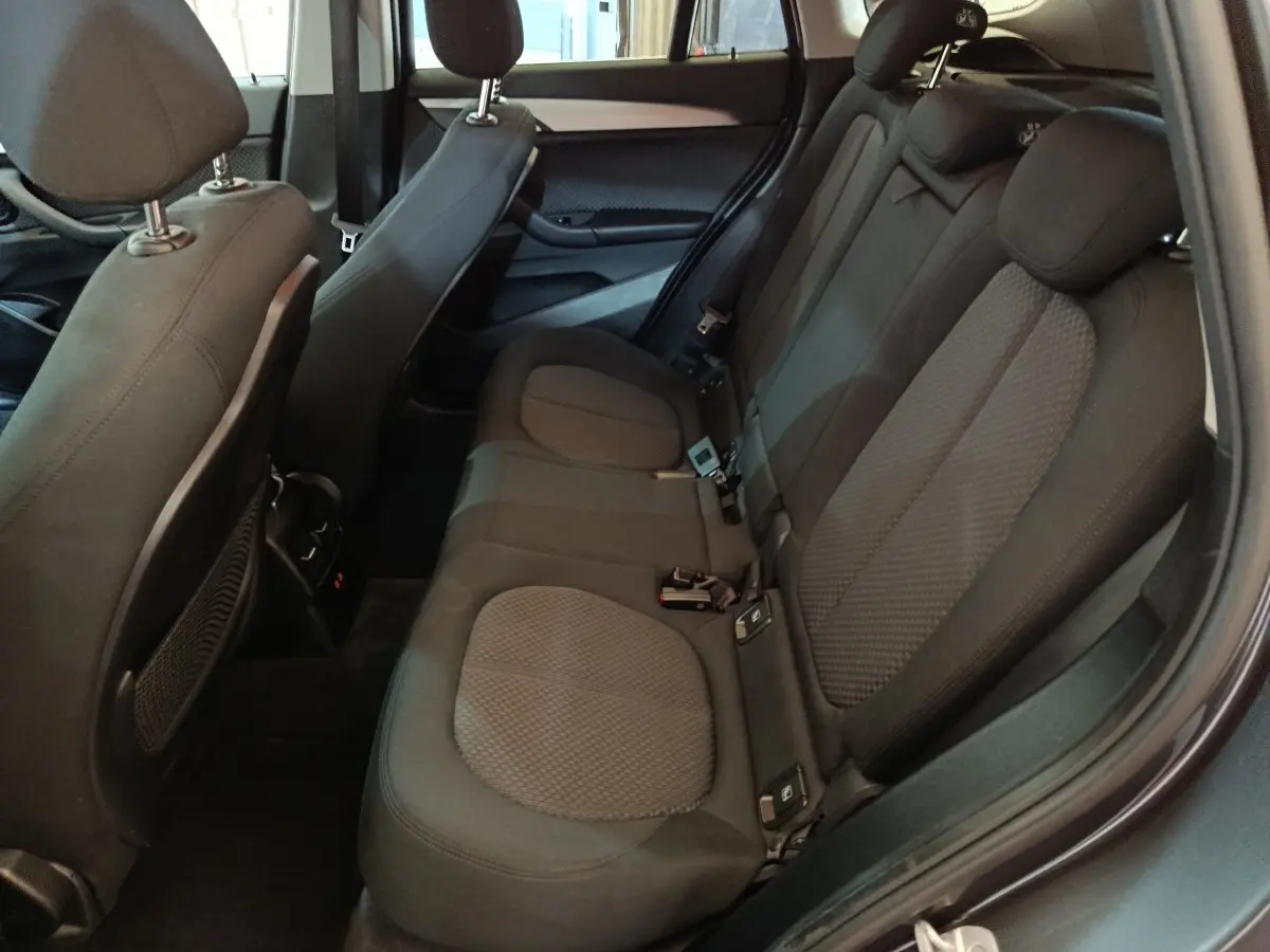 Vue intérieure côté droit des sièges arrière noirs du BMW X1 sDrive18i Lounge DKG7 gris foncé de 2021.