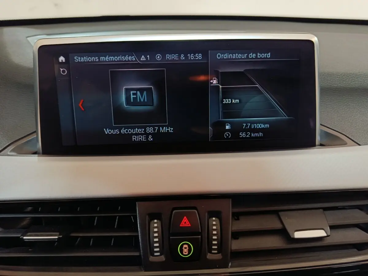 Écran central du tableau de bord de la BMW X1 sDrive18i 2021 affichant radio FM et ordinateur de bord.