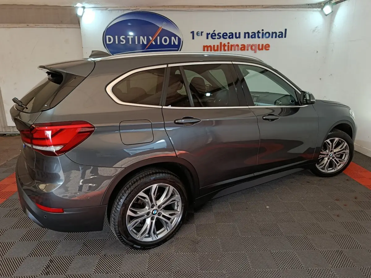 BMW X1 sDrive18i Lounge gris foncé vue de profil côté droit, avec jantes alliage et feux arrière LED visibles.