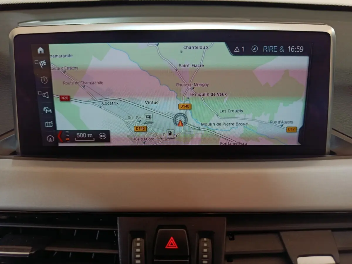 Écran tactile central affichant la navigation GPS du BMW X1 sDrive18i Lounge 2021, vue intérieure du tableau de bord.