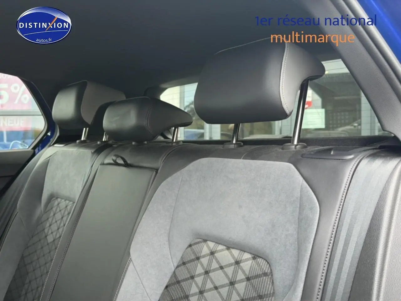 Vue intérieure sur la banquette arrière en tissu gris avec appuie-têtes noirs d’une Volkswagen Golf bleue 2024.