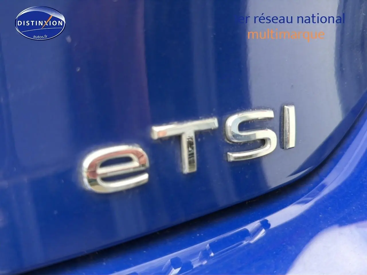 Gros plan sur le badge "eTSI" argenté sur la carrosserie bleue d'une Volkswagen Golf 2024.