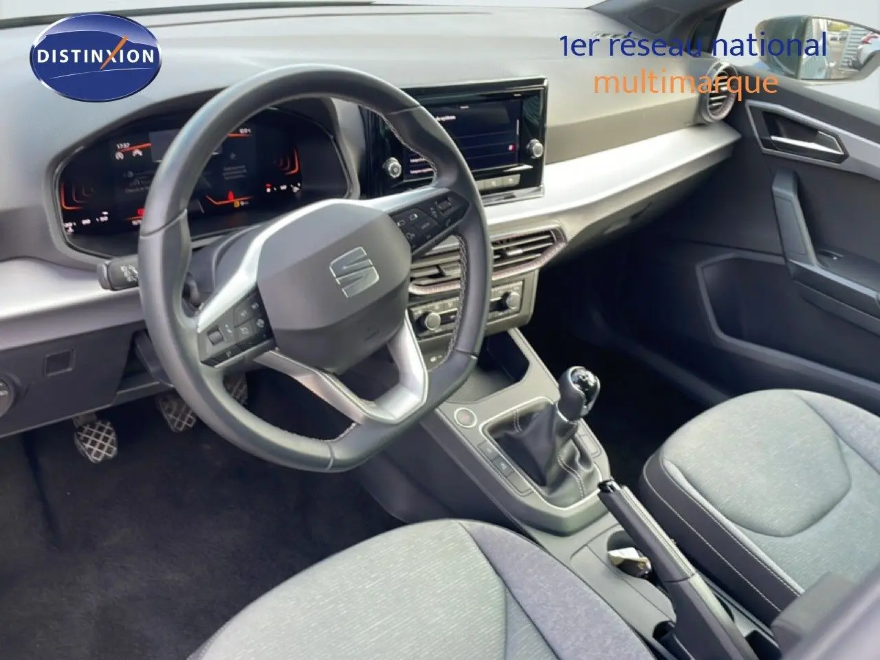 Vue intérieure de la SEAT Ibiza 2025, montrant le tableau de bord, volant cuir multifonction et levier de vitesses manuel.