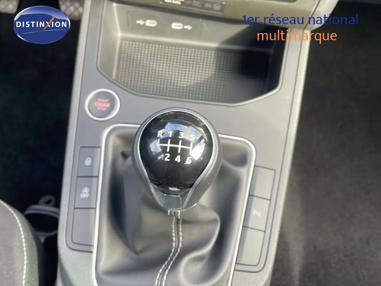 Gros plan sur le levier de vitesses manuel noir de la SEAT Ibiza 2025, entouré de commandes et console grise.