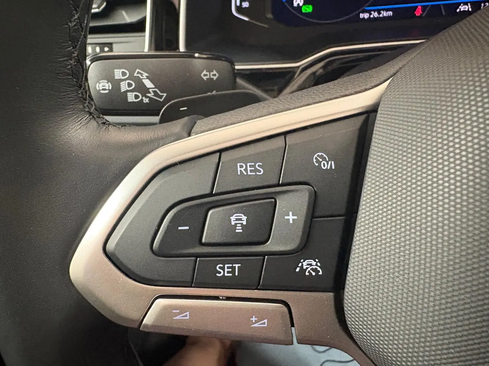 Gros plan sur les commandes au volant du Volkswagen Taigo 2024, boutons de régulateur de vitesse et assistance au maintien de voie.
