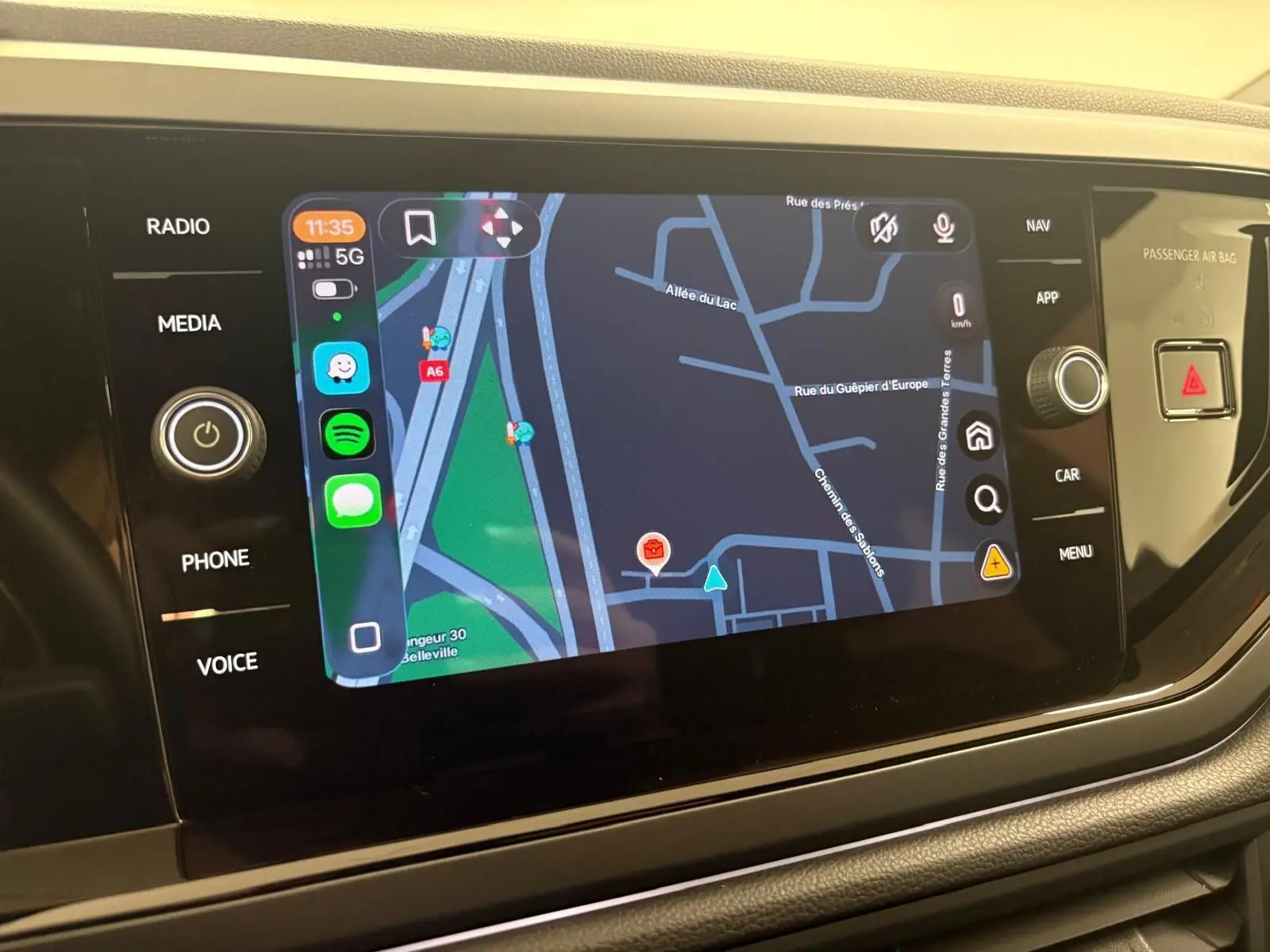 Écran tactile central du Volkswagen Taigo 2024 affichant une carte de navigation avec commandes latérales.