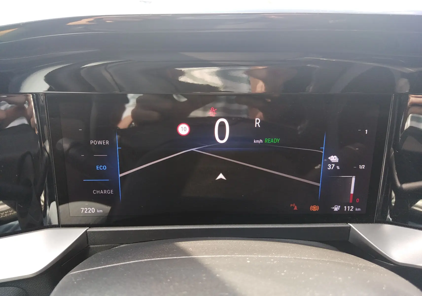 Tableau de bord numérique de l'Opel Mokka Electric gris, affichant la vitesse à 0 km/h et l'autonomie restante.