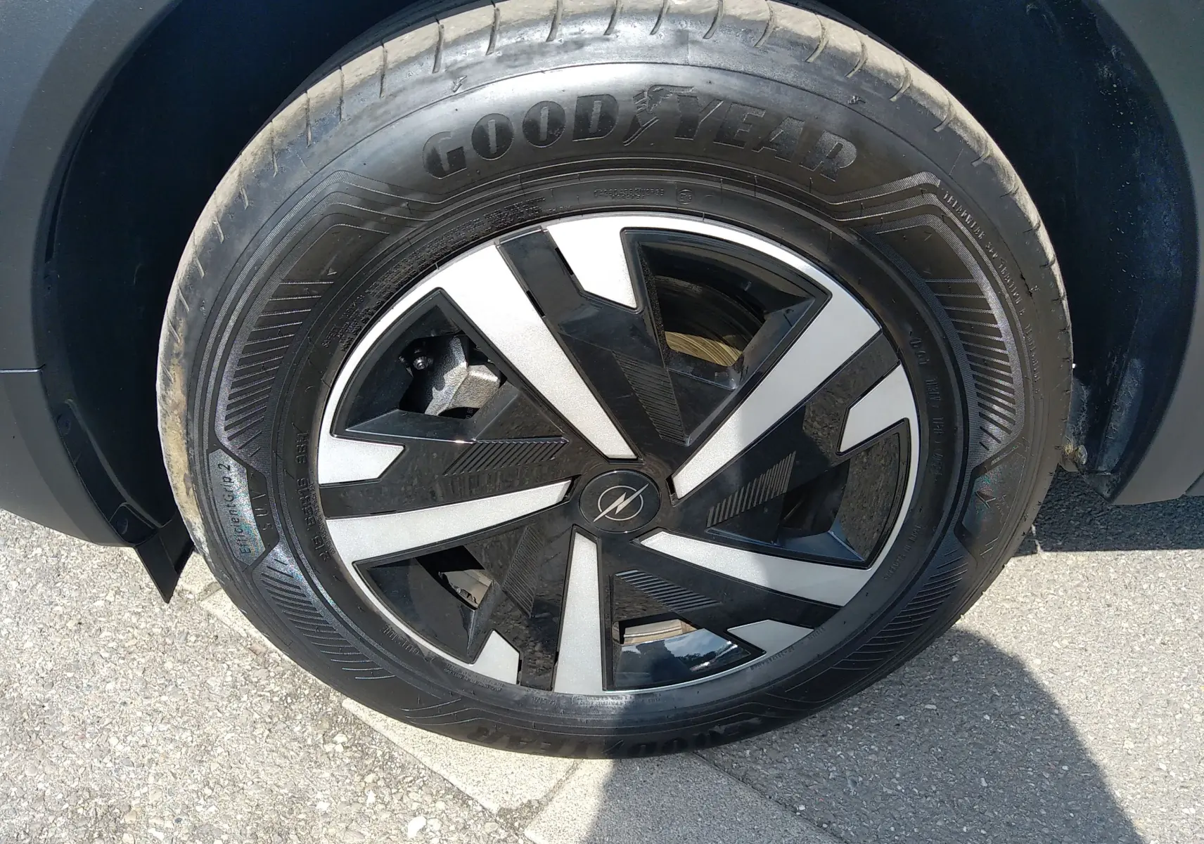 Gros plan sur la roue avant droite d’un Opel Mokka Electric gris, avec jante noire et argentée au design géométrique.