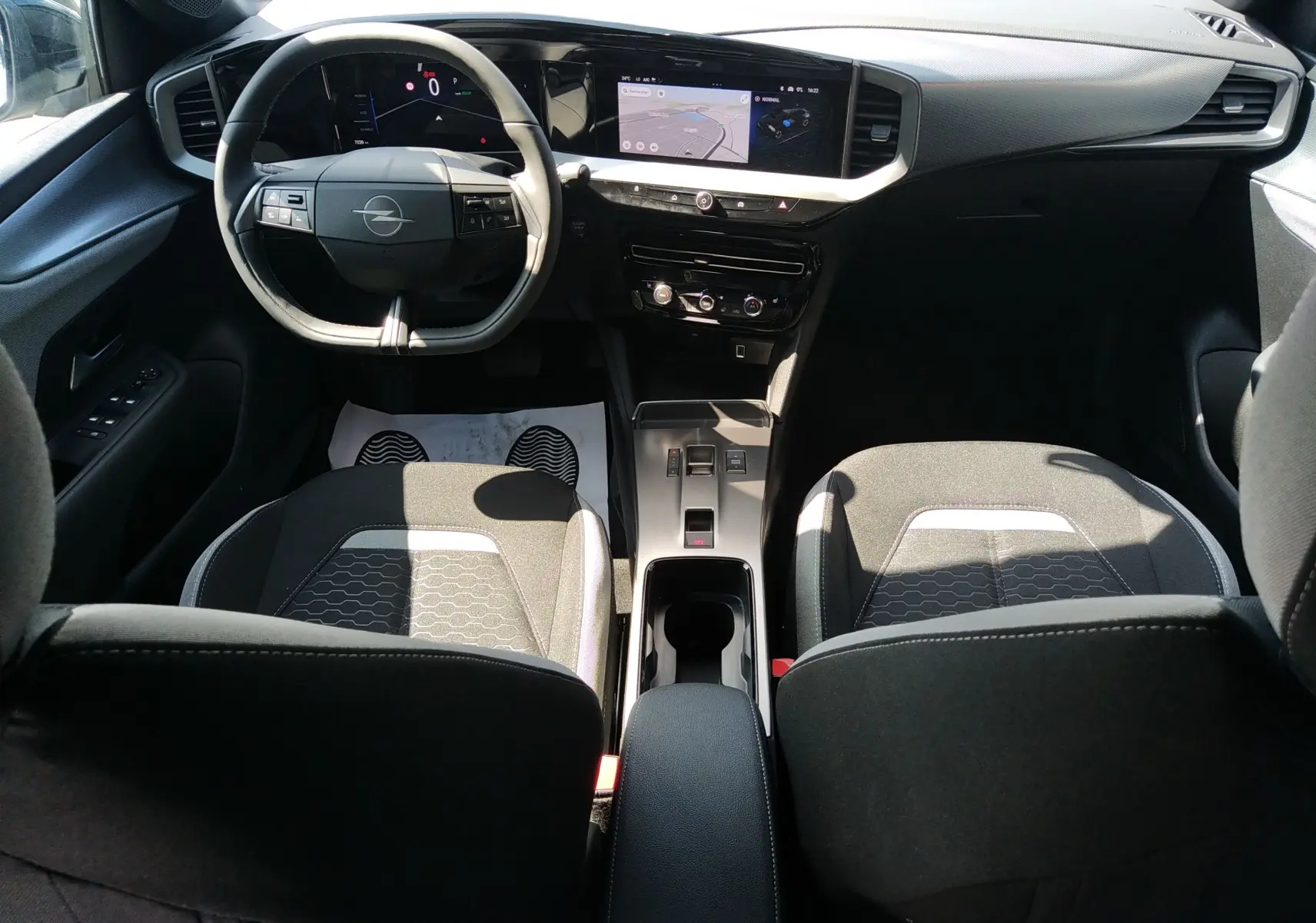 Intérieur de l’Opel Mokka Electric gris, vue avant centrée sur le tableau de bord numérique et l’écran tactile GPS.