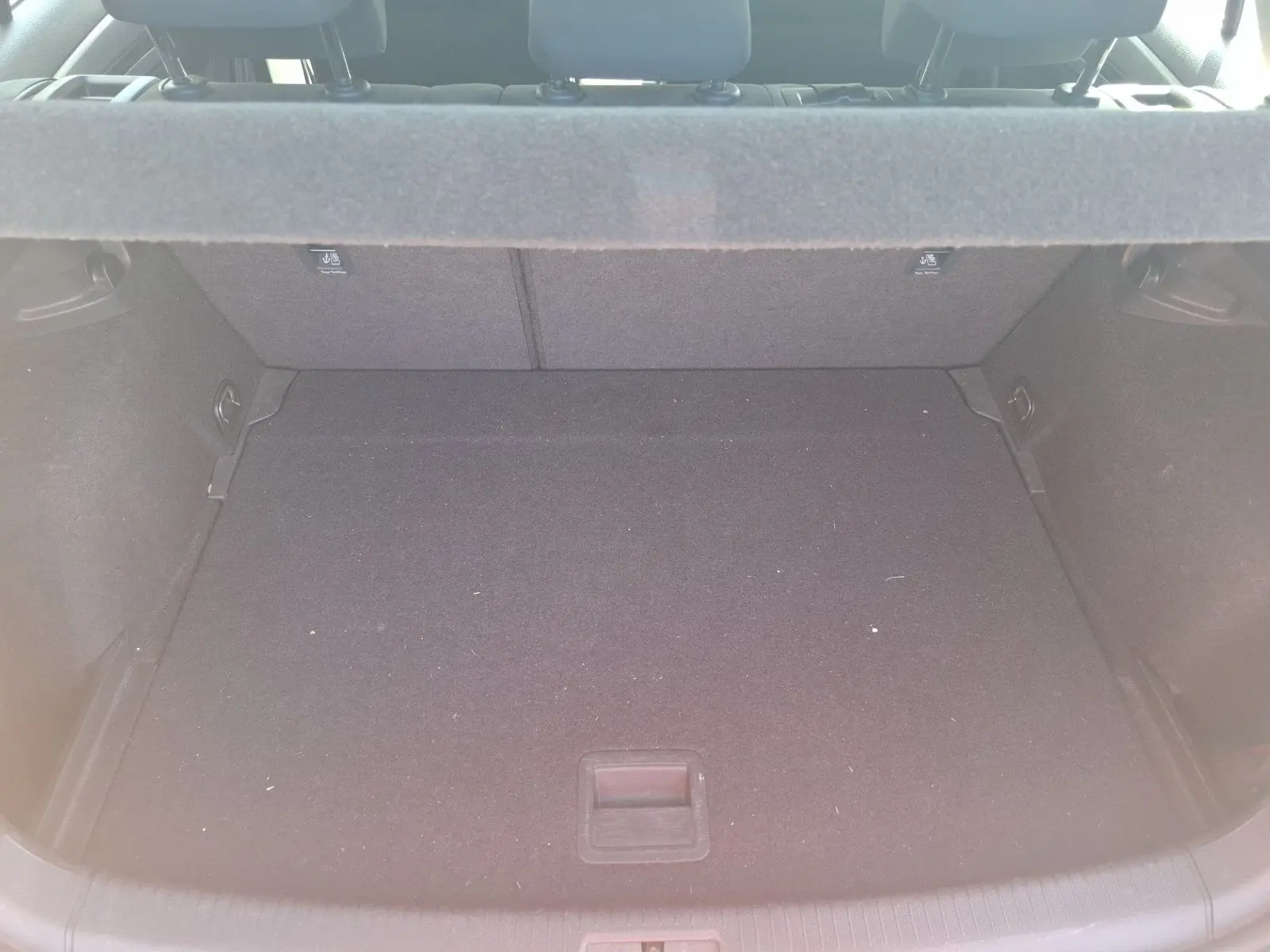 Coffre ouvert d’une Volkswagen Golf blanche 2019, vue de l’arrière, montrant un espace de chargement vide et propre.