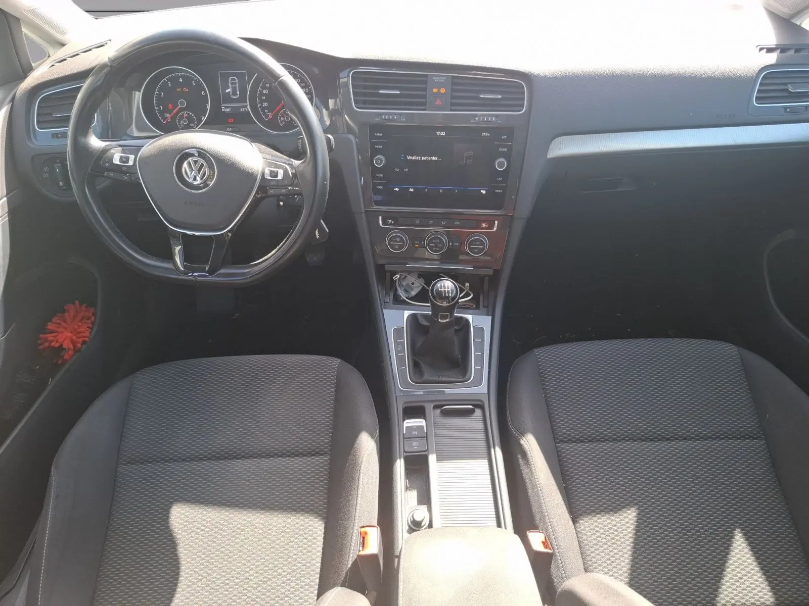 Vue intérieure avant de la Volkswagen Golf 2019, tableau de bord noir avec volant multifonction et boîte manuelle.