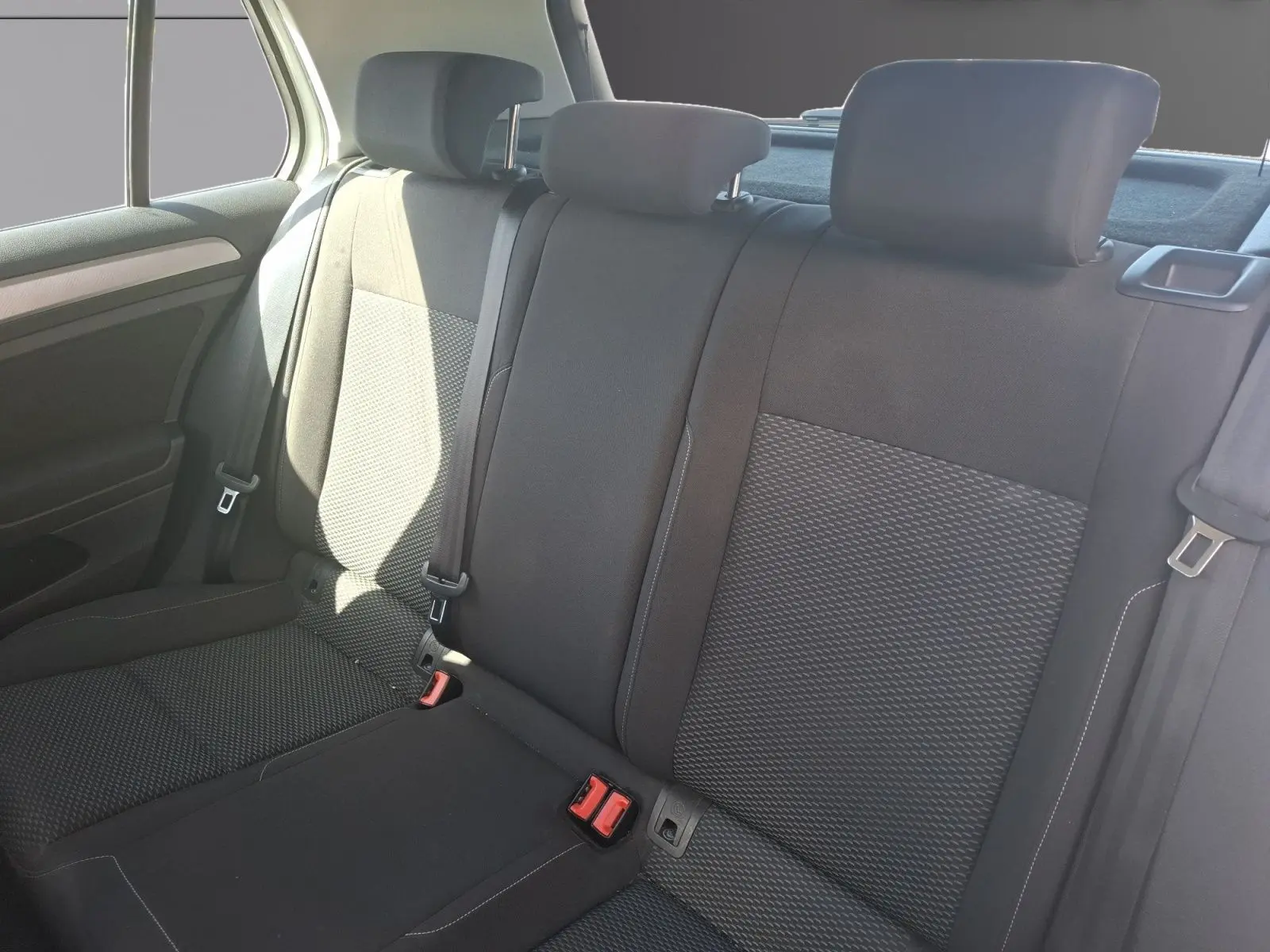 Vue intérieure des sièges arrière noirs du Volkswagen Golf 2019, avec appuie-têtes et ceintures visibles.