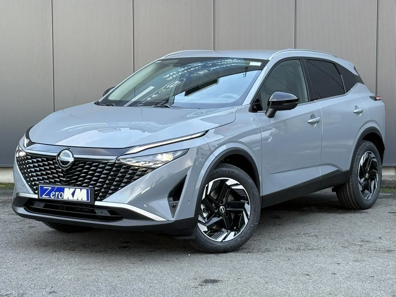 Nissan Qashqai III e-Power gris Ceramic en 3/4 avant droit, avec calandre noire et jantes alliage bicolores.