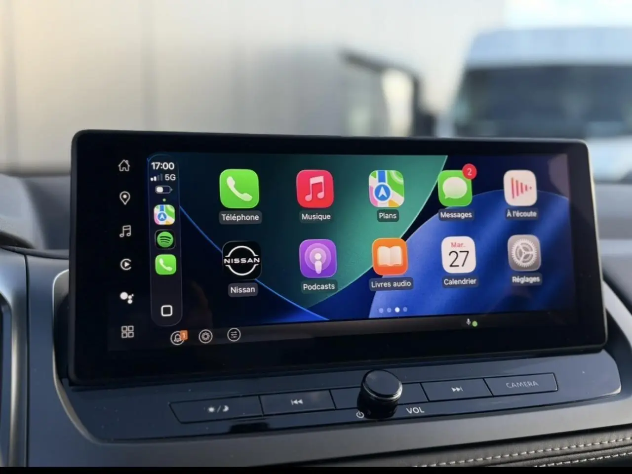 Écran tactile central du Nissan Qashqai 2025 affichant Apple CarPlay avec icônes colorées, vue intérieure frontale.