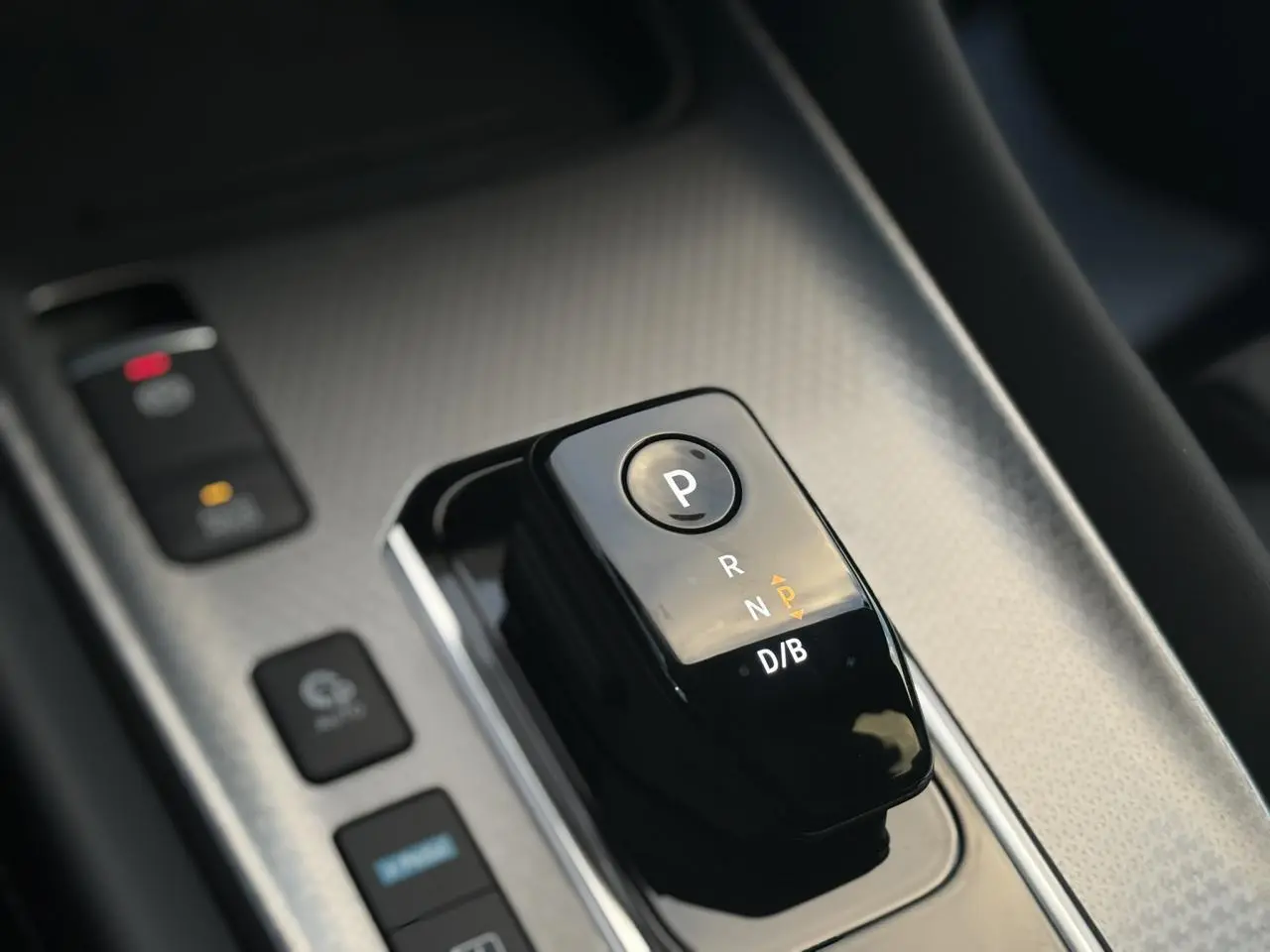 Gros plan sur le sélecteur de boîte automatique noir brillant du Nissan Qashqai III e-Power, intérieur gris texturé.