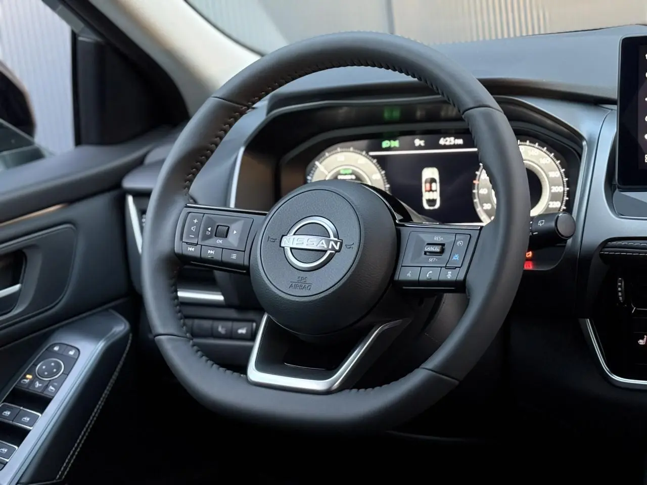 Vue rapprochée du volant cuir noir du Nissan Qashqai 2025 avec commandes intégrées et tableau de bord numérique.