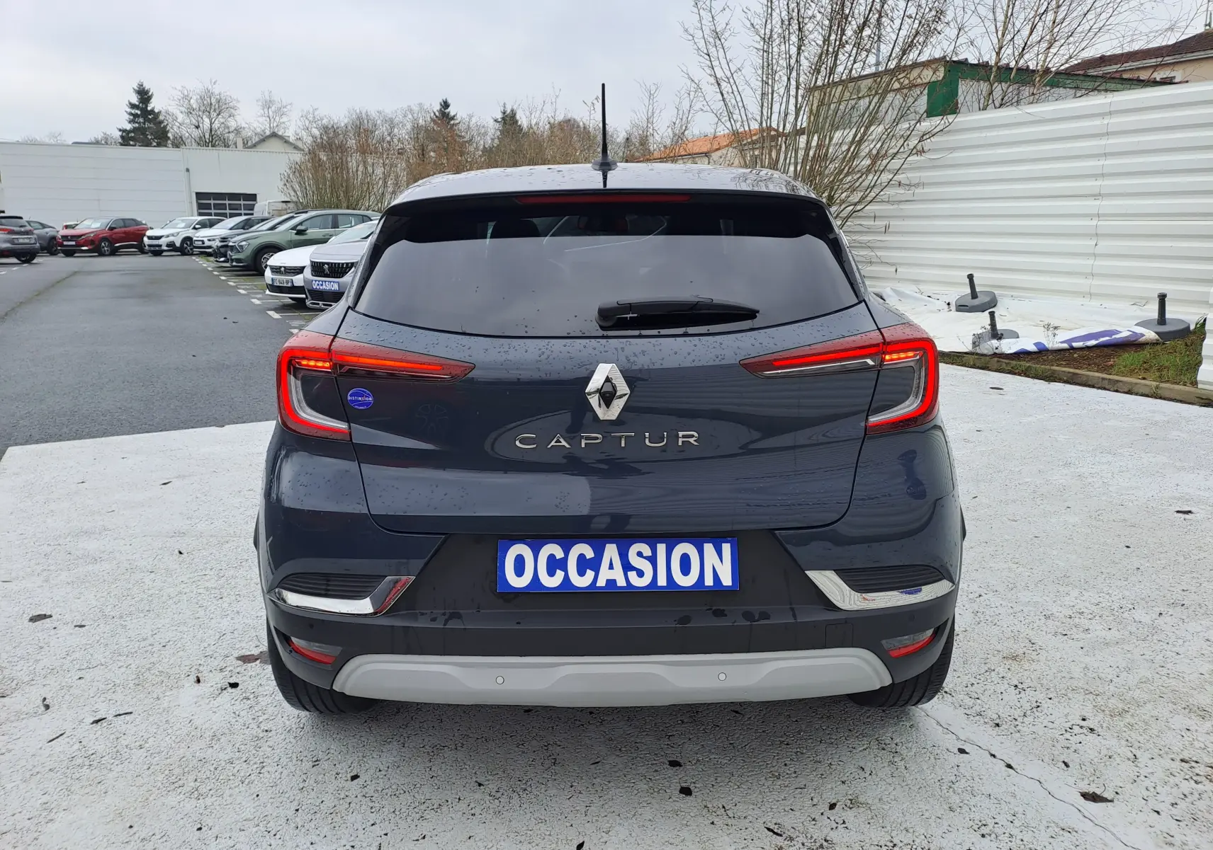 Vue arrière d'un Renault Captur bleu marine 2022 avec feux LED allumés et plaque "OCCASION" visible.